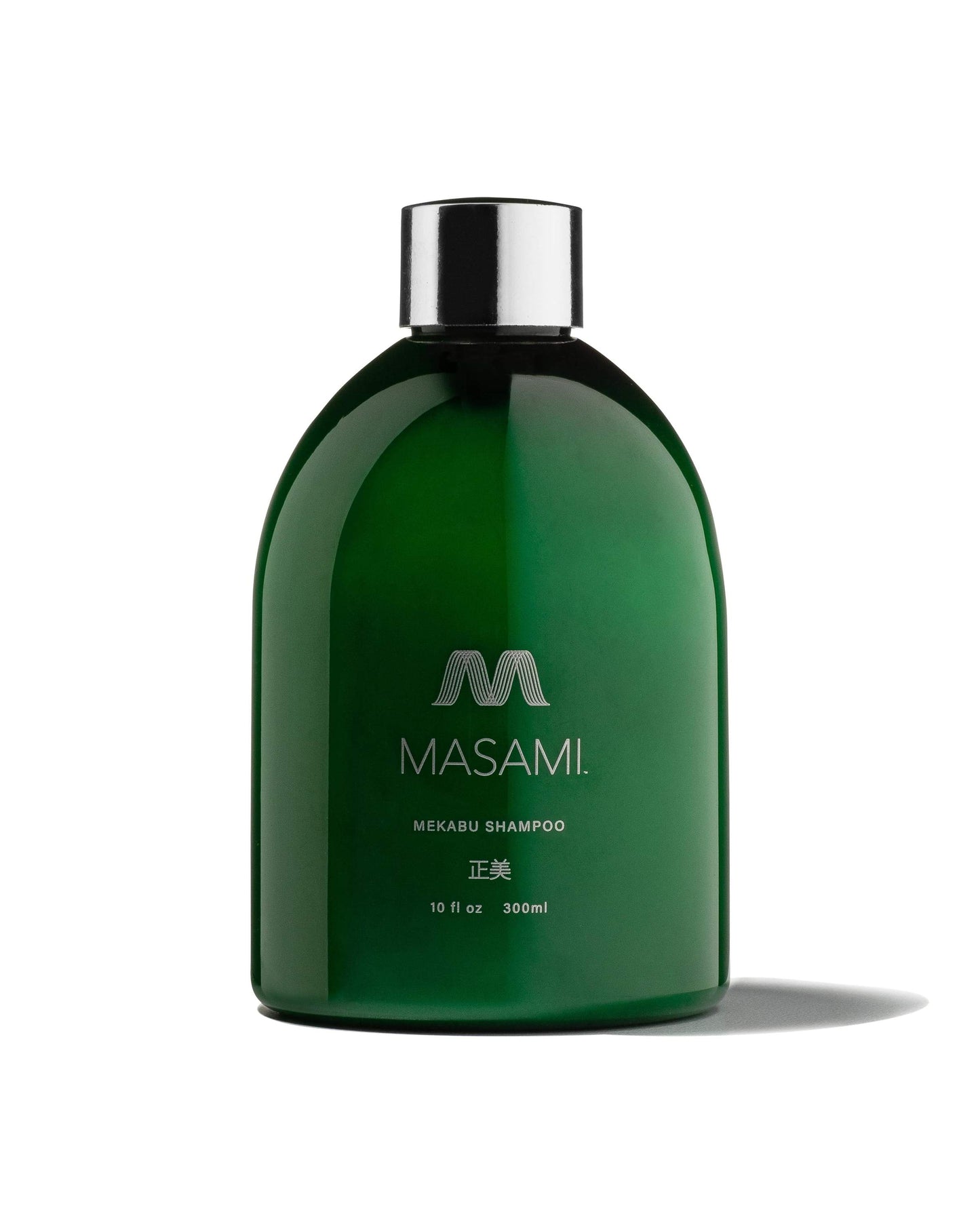 Green shampoo bottle with silver cap on a white background
