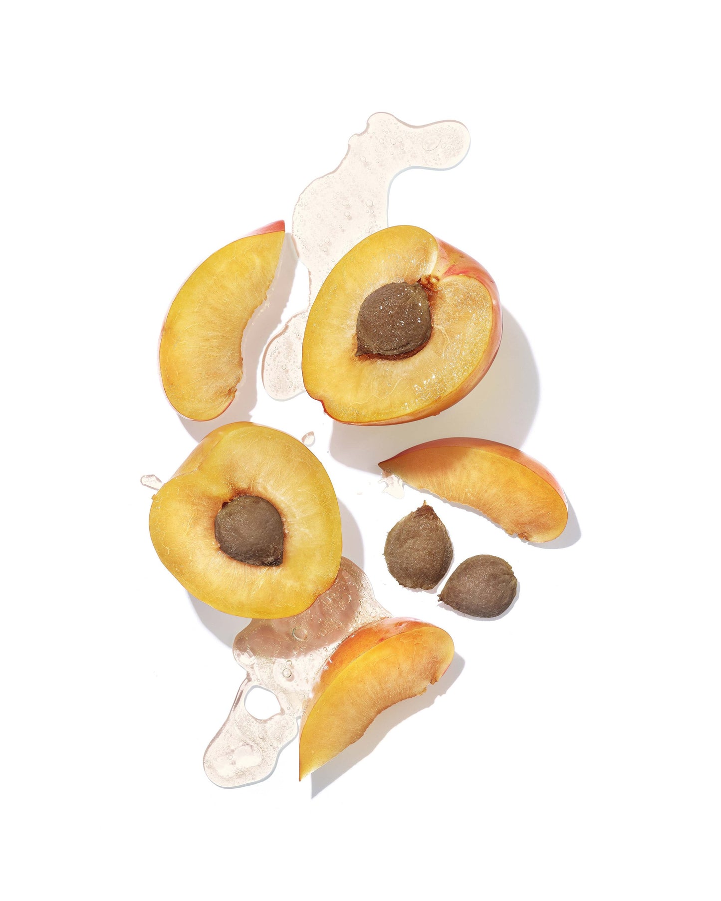 Peach slices with pits on a white background