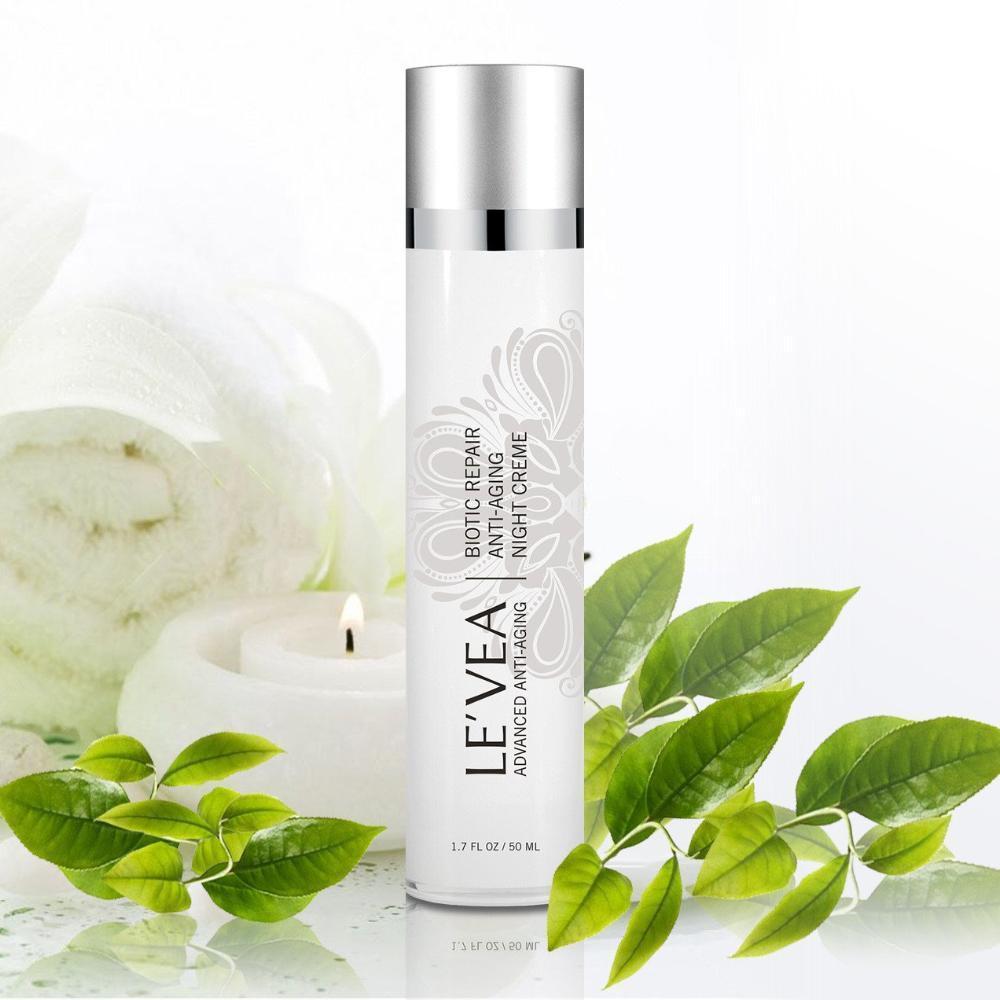 Le'Vea skincare bottle with green leaves and a candle on a white background