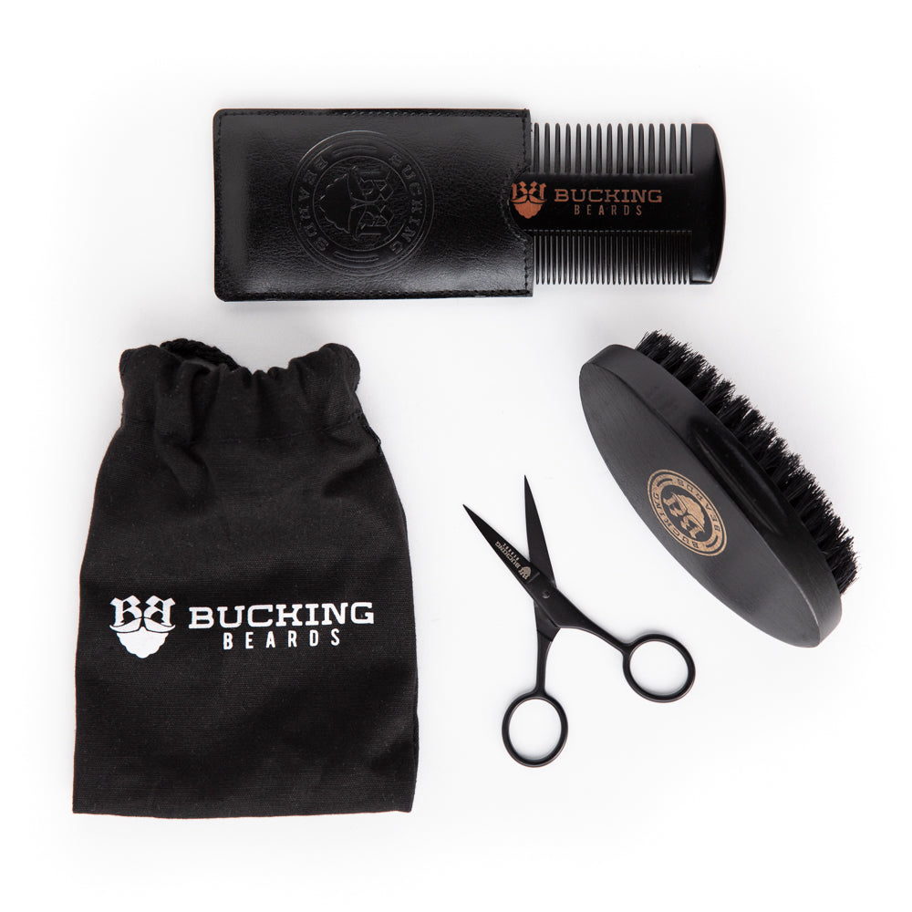 Beard grooming kit with comb, scissors, brush, and pouch on a white background