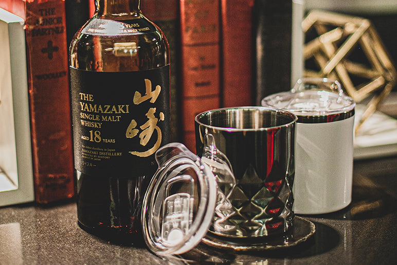 Yamazaki 18-year-old single malt whiskey bottle with a glass on a wooden surface.
