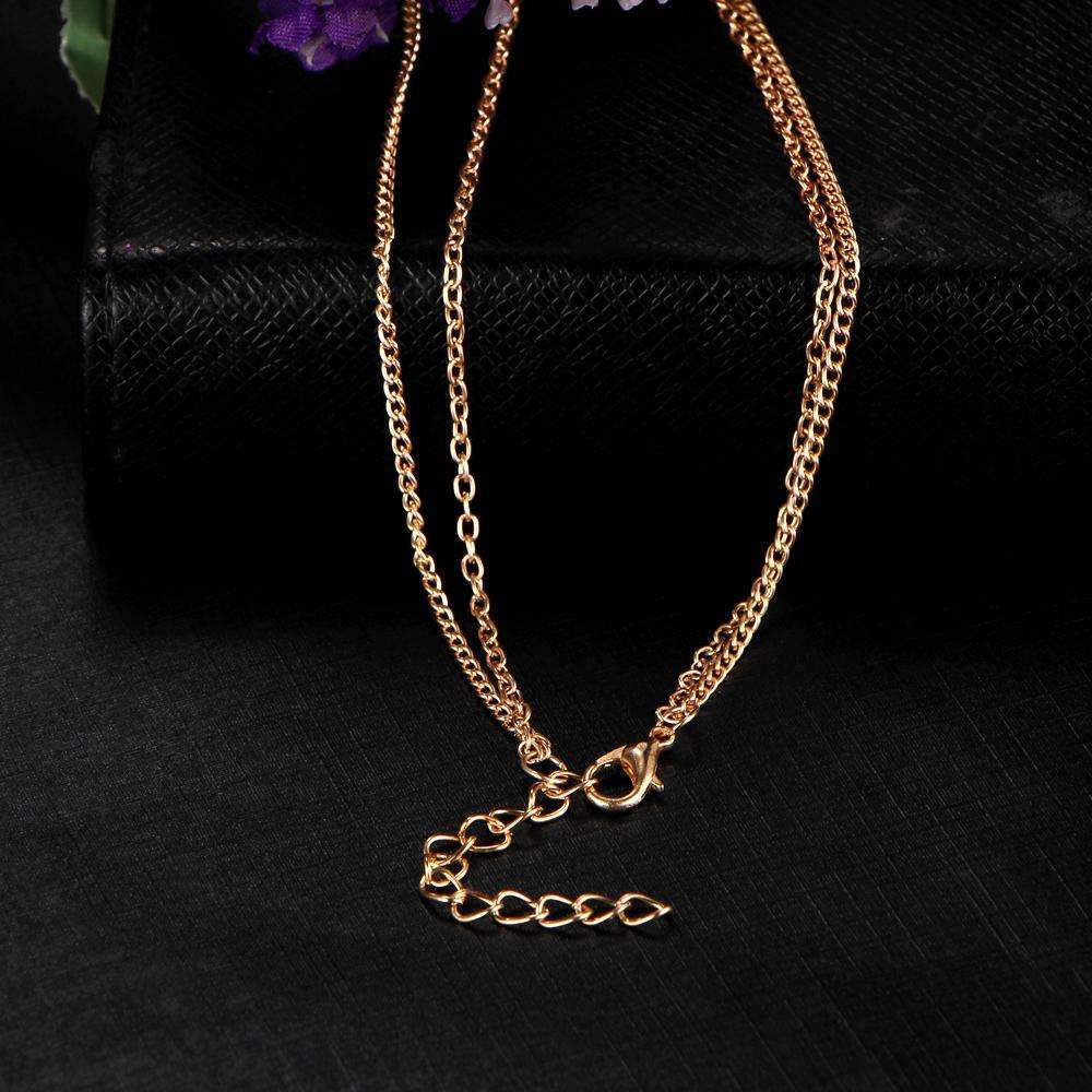 Gold chain necklace on a black textured surface