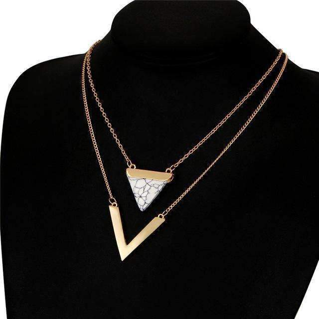 Necklace with a gold and white triangle pendant on a black background