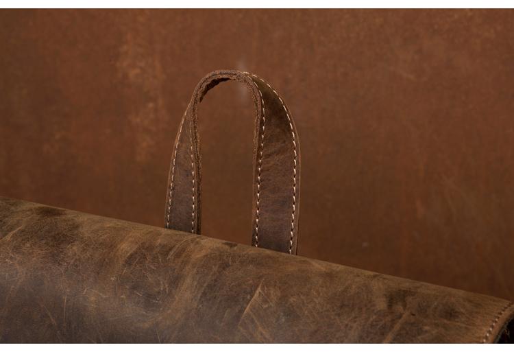 Close-up of a brown leather bag with visible stitching on a matching brown background