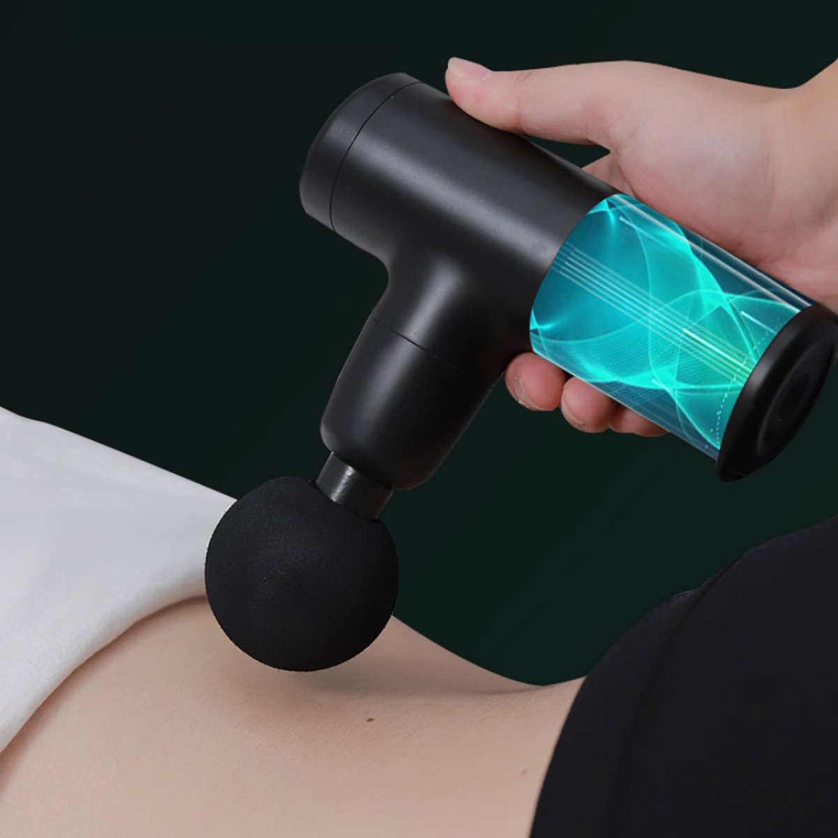 Hand holding a black massage gun with a green light on a dark background