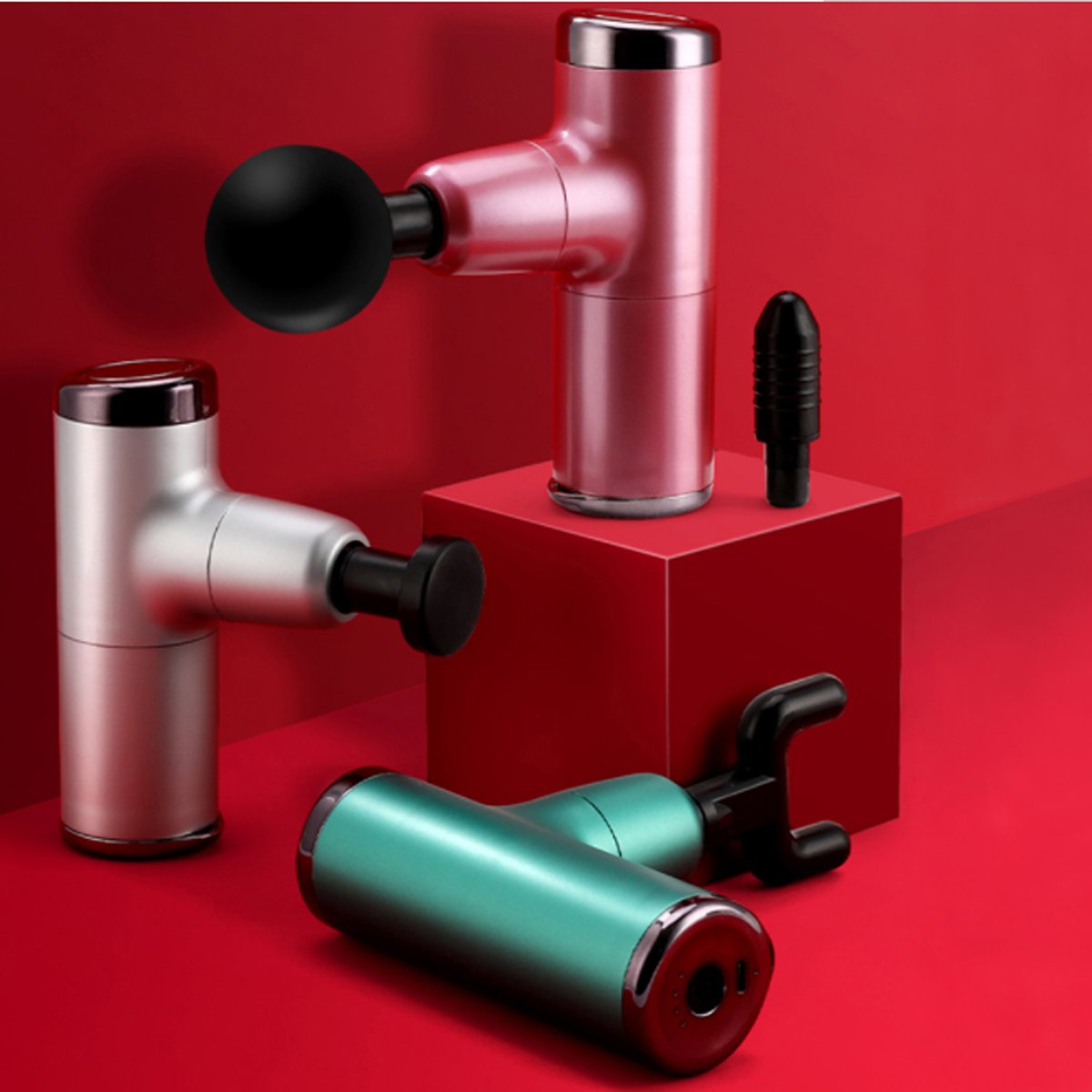 Three massage guns in red, silver, and teal on a red background