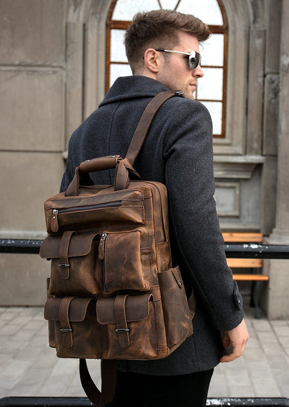 Man wearing a brown leather backpack outdoors.