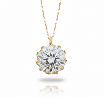 Gold necklace with a large diamond pendant on a white background