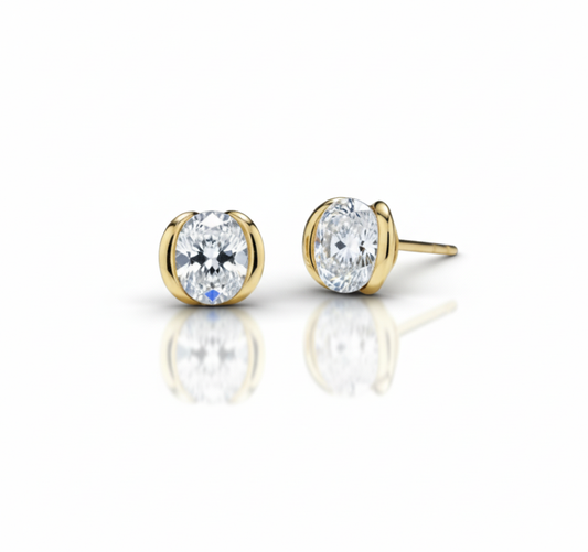 Gold stud earrings with clear gemstones on a white background