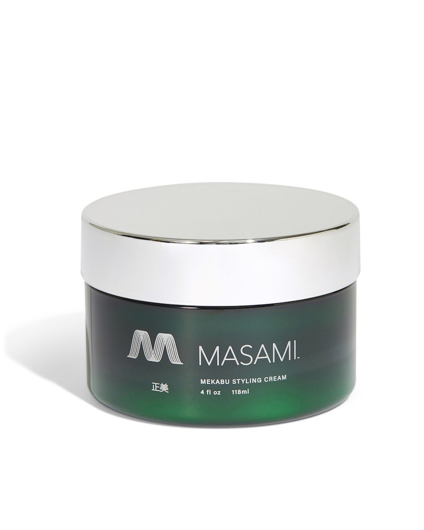 Green jar of MASAMI styling cream with silver lid on a white background