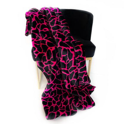 Black and pink patterned blanket draped over a black chair on a white background