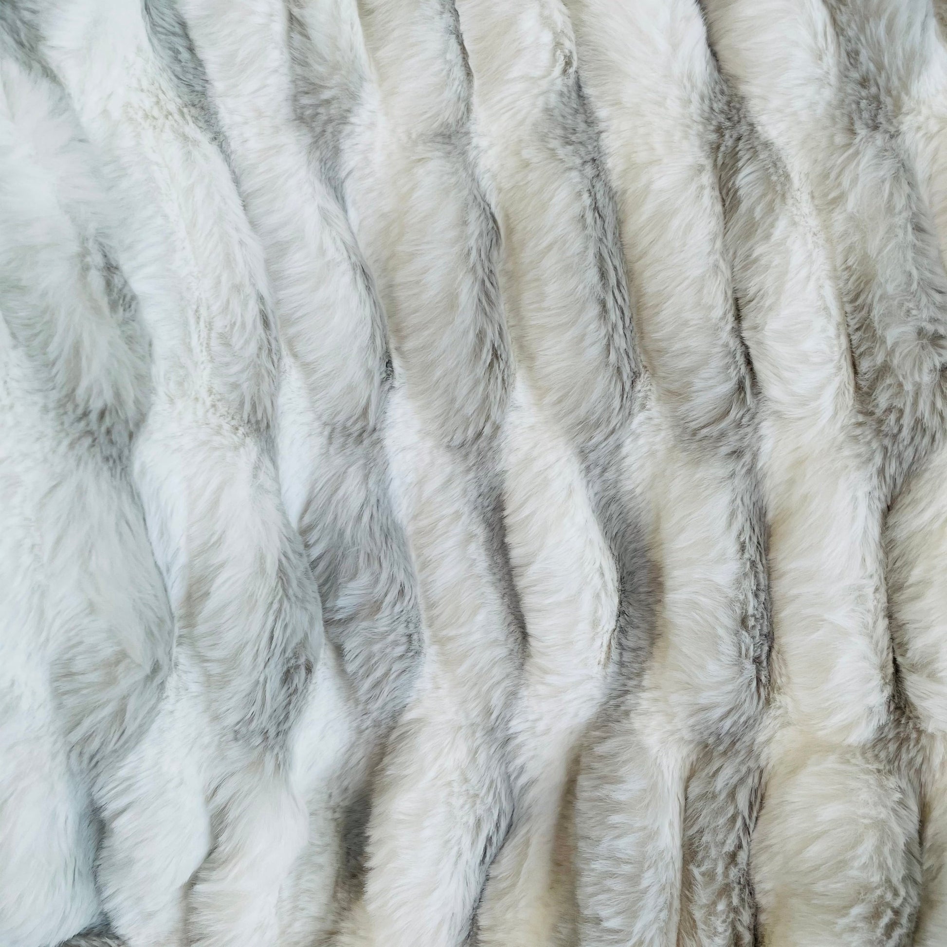 Close-up of gray and white faux fur throw blanket texture