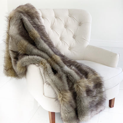 Fur throw draped over a white chair on a white background