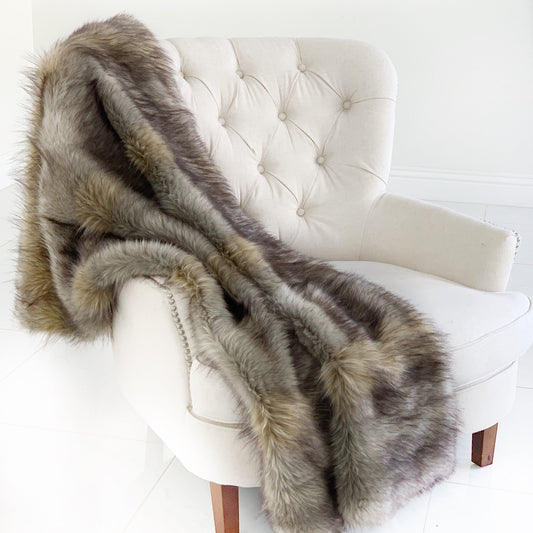 Fur throw draped over a white chair on a white background