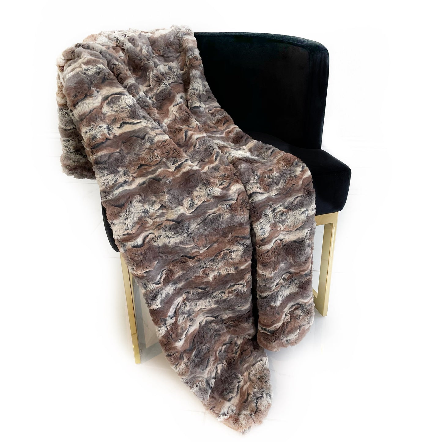 Brown faux fur throw blanket draped over a black chair on a white background