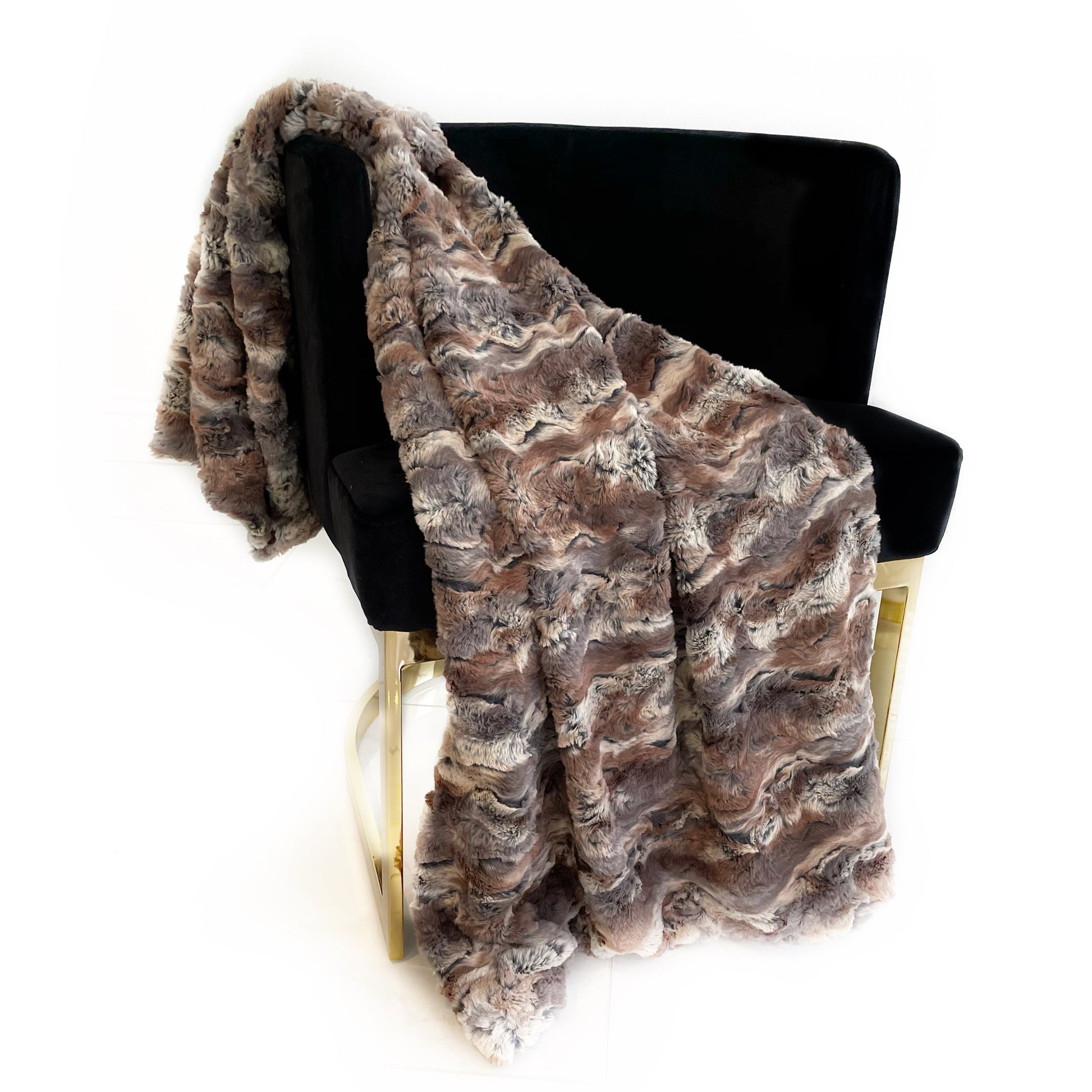 Brown textured faux fur blanket draped over a black chair on a white background