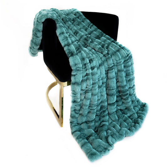 Teal textured blanket draped over a black chair on a white background