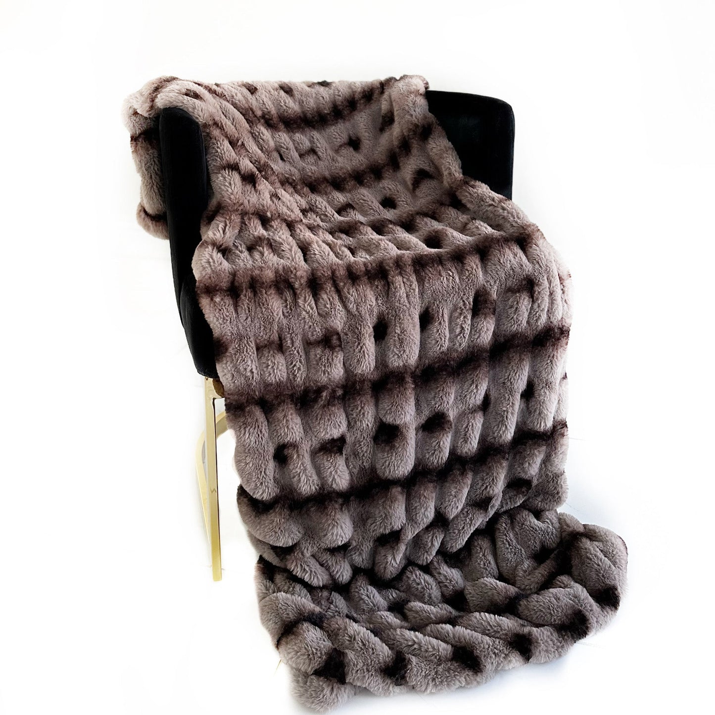 Knitted blanket draped over a chair on a white background