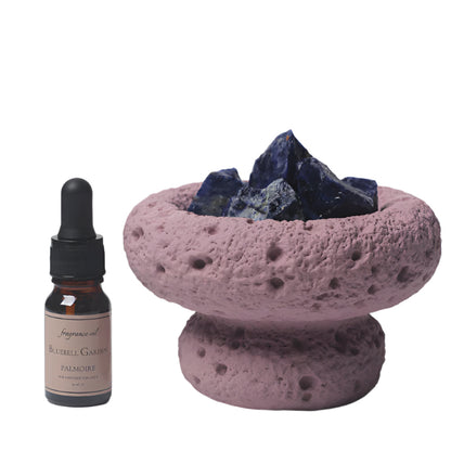 Purple Moon Diffuser with Amethyst quartz crystals and a bottle of Bluebell Garden essential oil on a white background
