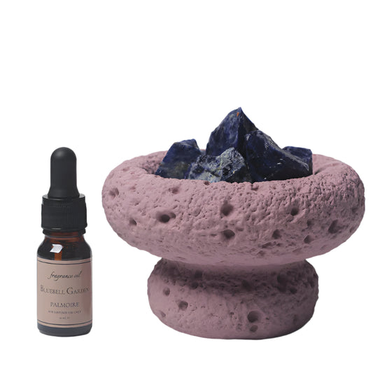 Purple Moon Diffuser with Amethyst quartz crystals and a bottle of Bluebell Garden essential oil on a white background