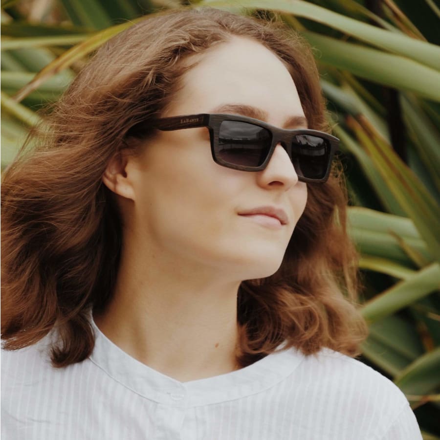 Person wearing sunglasses with a blurred natural background