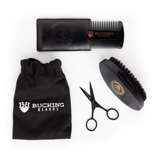 Beard grooming kit with comb, scissors, brush, and pouch on a white background