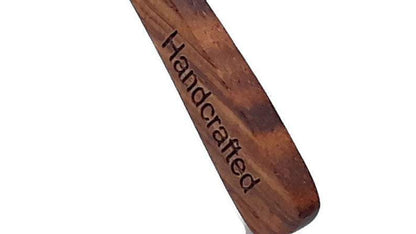 Wooden sunglass frame with 'Handcrafted' engraving on a white background