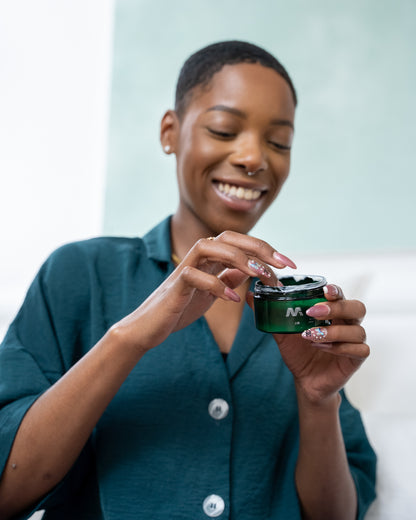 Woman holding a green container with a brand logo, wearing a teal shirt.