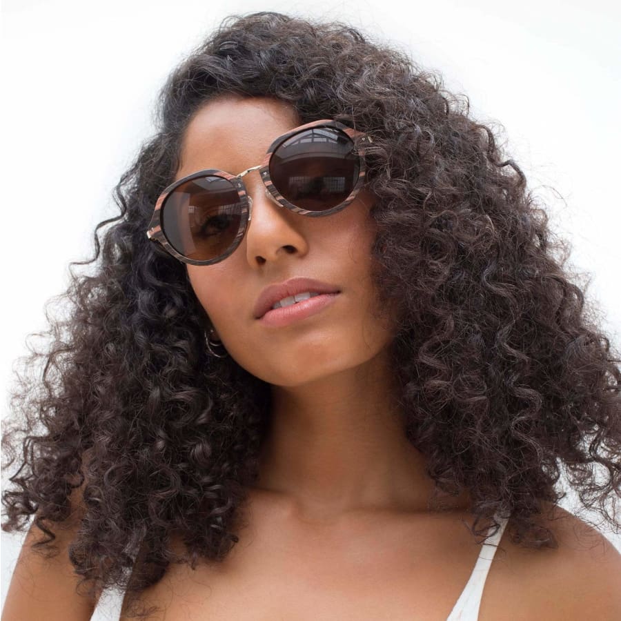 Woman wearing sunglasses with a neutral background