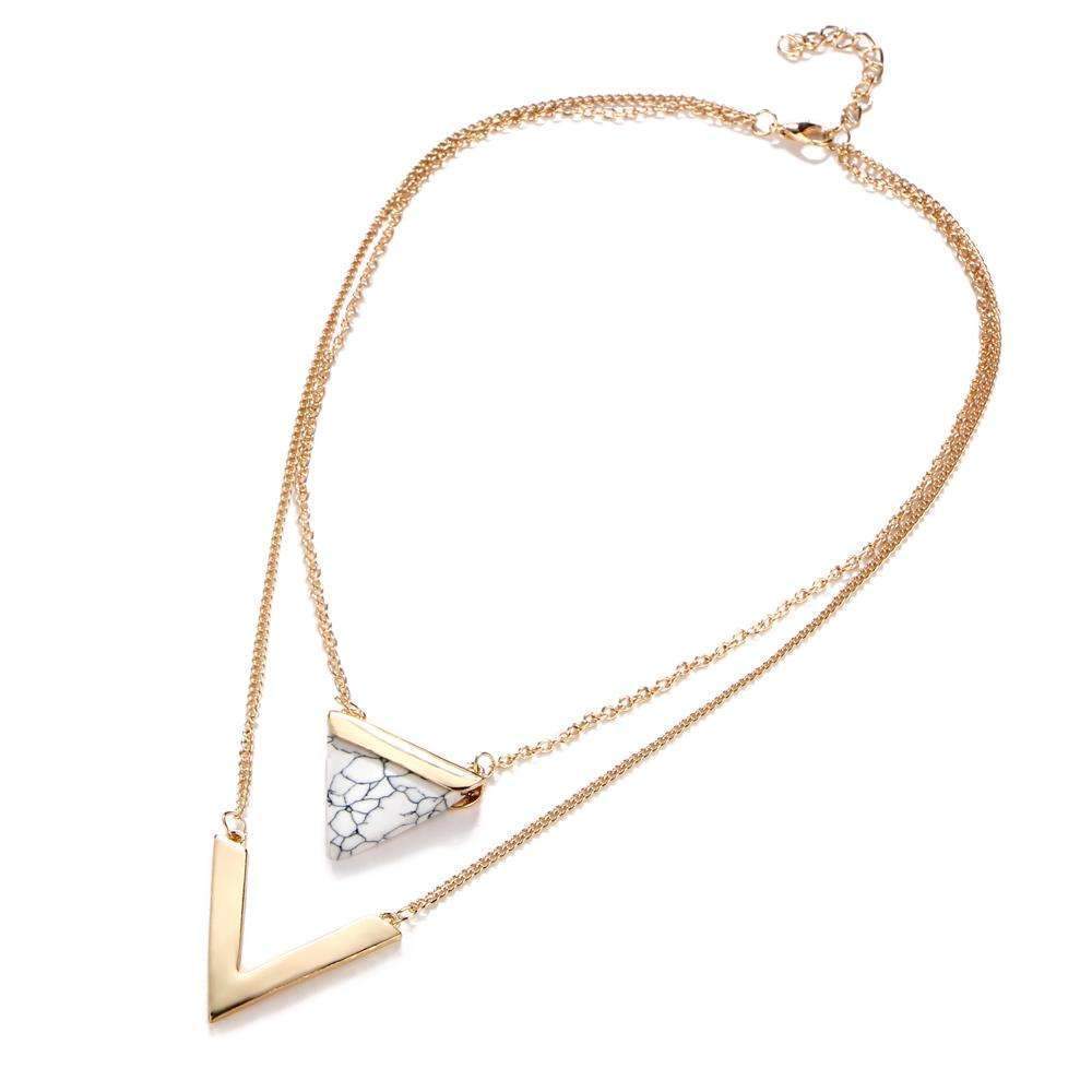 Gold necklace with a geometric pendant on a white background