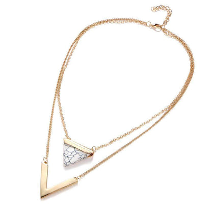 Gold necklace with a geometric pendant on a white background