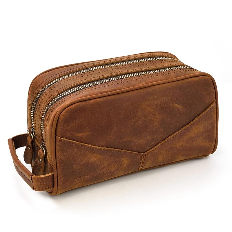 Brown leather toiletry bag with multiple zippers on a white background