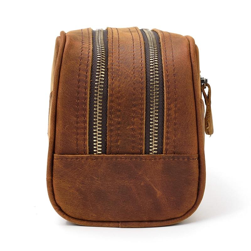 Brown leather toilet bag with two zippers on a white background