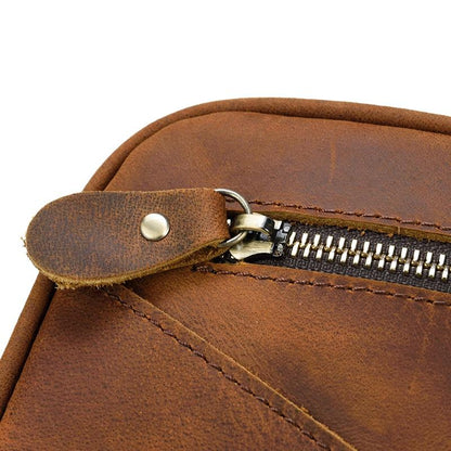 Close-up of a brown leather toilet bag with a zipper