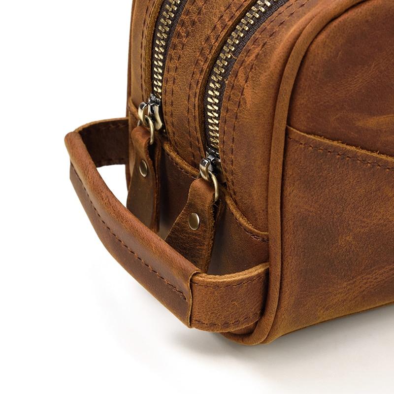 Brown leather bag with gold zipper on a white background