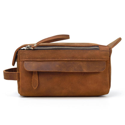 Brown leather toiletry bag with a strap on a white background