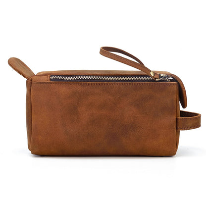 Brown leather toiletry bag with handles on a white background