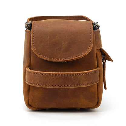 Brown leather toiletry bag with a flap on a white background
