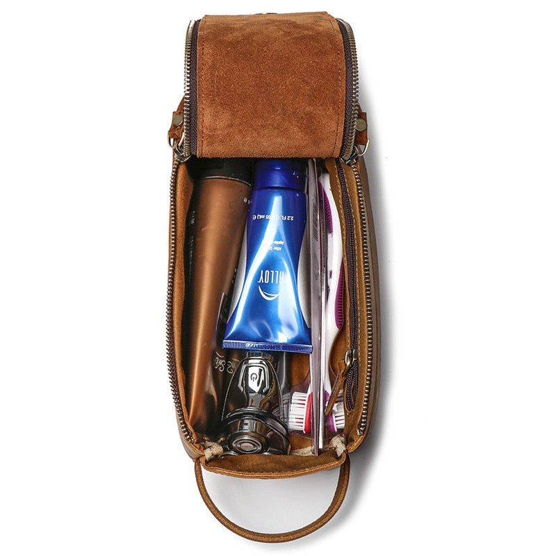 Brown leather toiletry bag with products inside on a white background