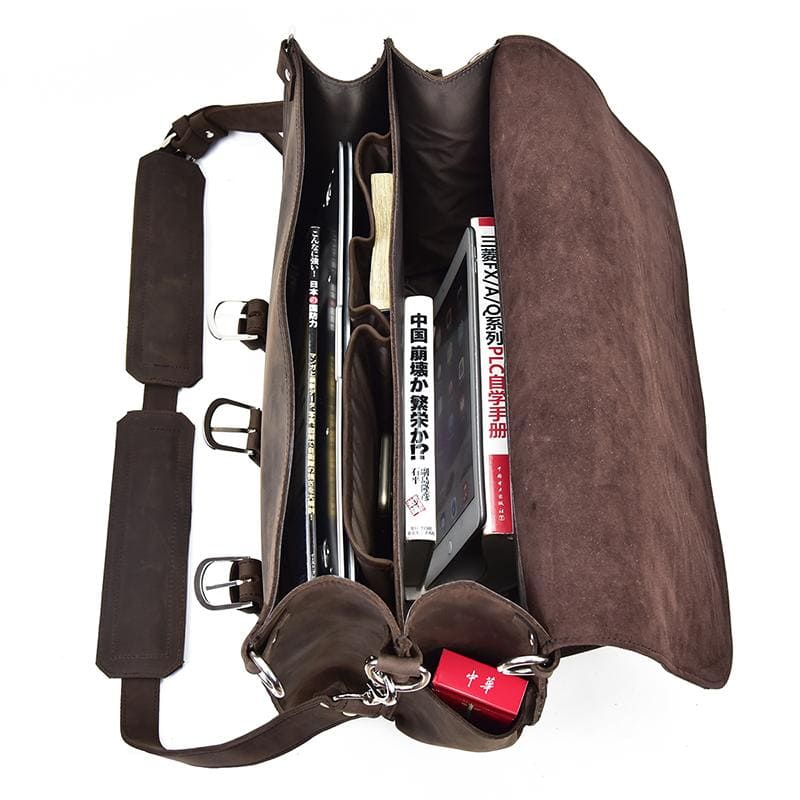 Brown leather bag with various items inside on a white background