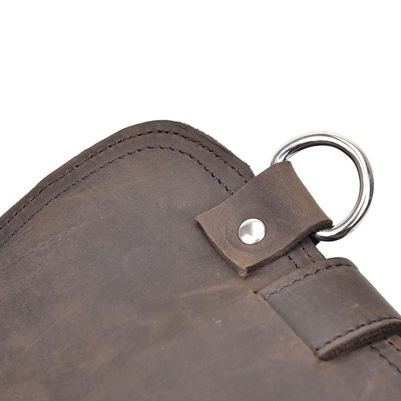 Close-up of a brown leather bag with a metal ring and button on a white background
