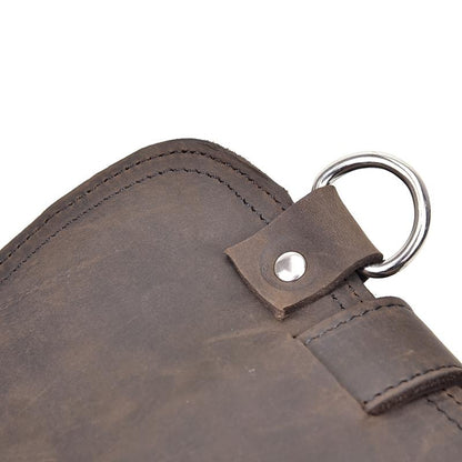 Close-up of a brown leather bag with a metal ring and button on a white background