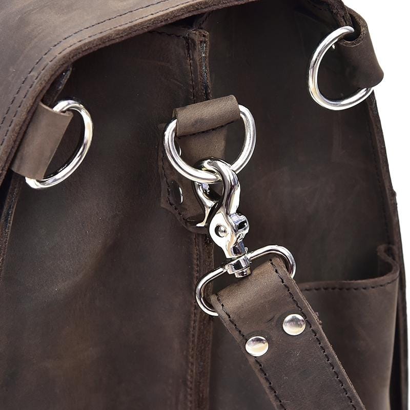 Close-up of a brown leather bag with silver metal rings and clasps.