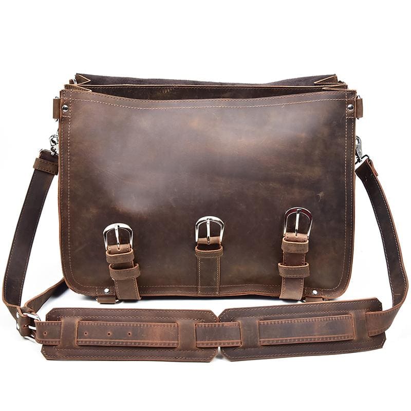 Brown leather messenger bag with metal buckles on a white background