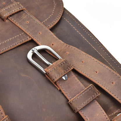 Close-up of a brown leather bag with a silver buckle on a white background