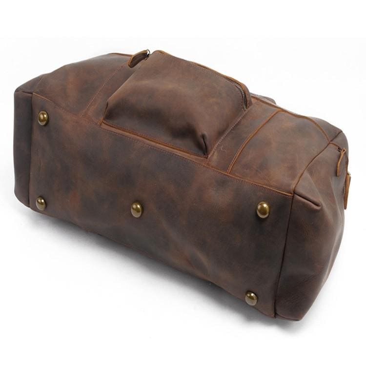 Brown leather duffel bag with gold rivets on a white background