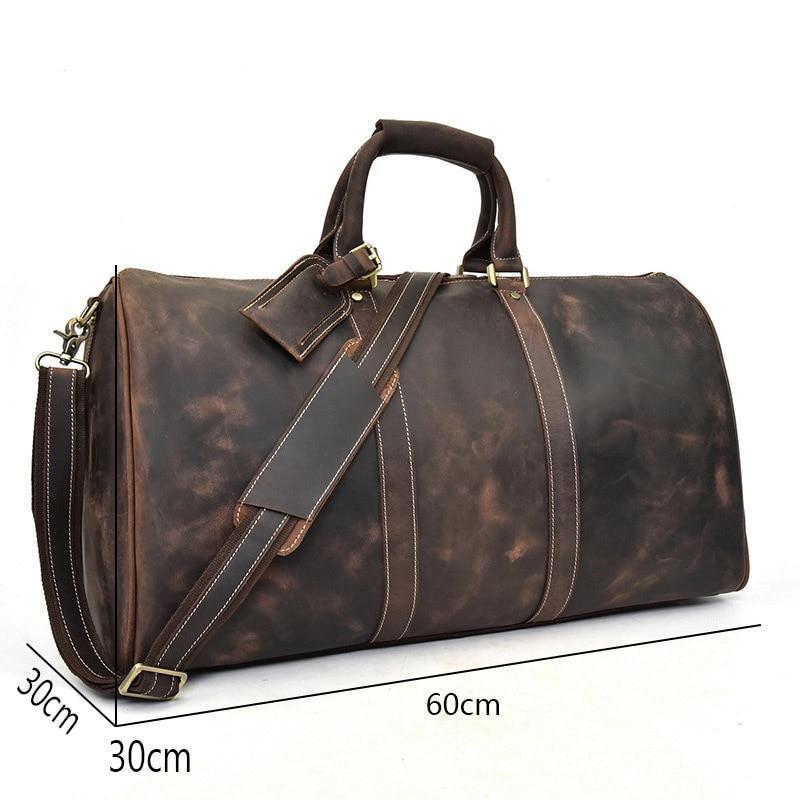 Brown leather duffel bag with measurements on a white background