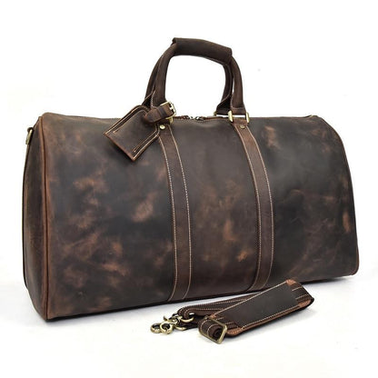 Brown leather duffel bag with gold accents on a white background