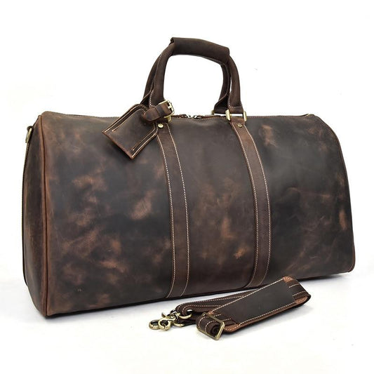 Brown leather duffel bag with gold accents on a white background