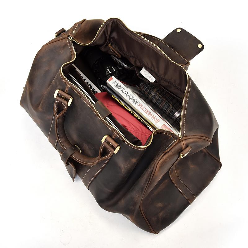 Brown leather duffel bag with gold zippers on a white background